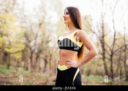 Seitenansicht des Fit junge Frau in Sportkleidung, immer bereit für Training. Gesunde Frau im Park an einem sonnigen Tag. Stockfoto