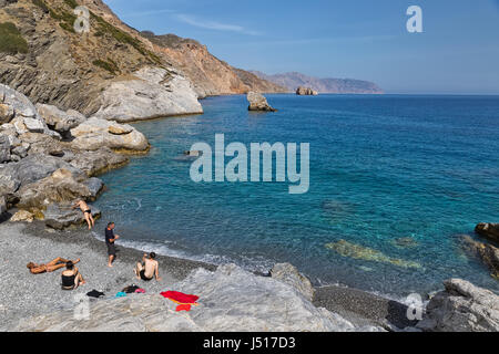 Insel Amorgos, Griechenland - Oktober 2015: Firma junger Menschen am Strand von einer griechischen Insel Amorgos Stockfoto