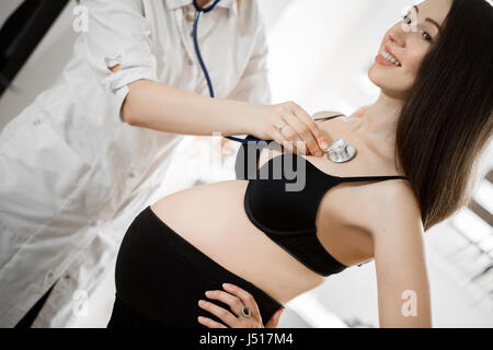 weibliche Medizin Arzt Holding Stethoskop, schwangere Frau stehend für Ermutigung, Empathie, Jubel, Unterstützung, ärztliche Untersuchung. Neues Leben der Abtreibung Konzept. Stockfoto