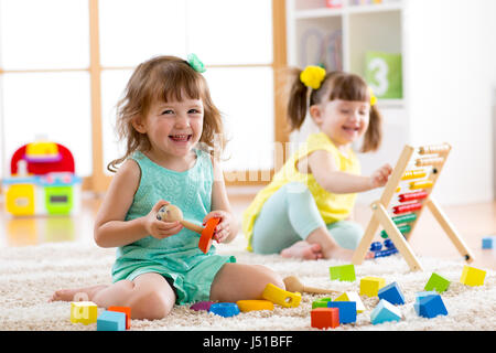 Kleine Kinder spielen mit Abacus und Konstruktor Spielzeug Erdgeschoss im Kindergarten oder zu Hause. Frühes lernen Konzepte. Stockfoto