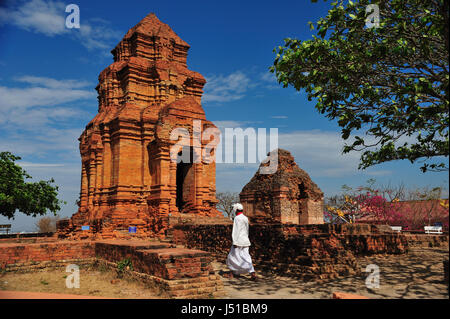 Ein Mann mit traditionellen cham Kleid ist zu Fuß in Thap Po sah Inu Tempel, 15. Jahrhundert Cham Turm Ruinen in Phan Thiet, Binh Thuan Provinz, Vietnam Stockfoto