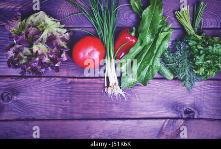 Frische Tomaten Gemüse, Gurken, Zwiebeln und Salat auf eine braune hölzerne Oberfläche, leerer Raum an der Unterseite, Vintage Muskelaufbau Stockfoto