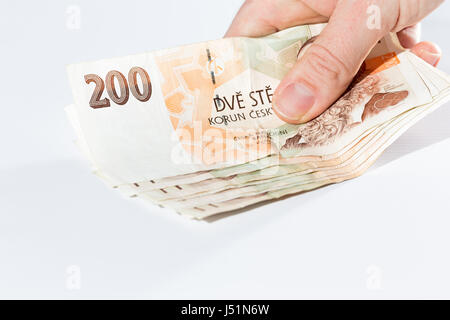 Nahaufnahme von weiblicher Hand, die tschechischen Banknoten isoliert auf weißem Hintergrund Stockfoto