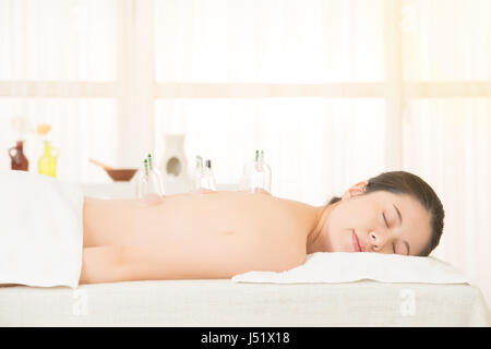 Frau in der alternativen Medizin Schröpfen Therapie mit Tassen auf dem Rücken in der chinesischen Medizin Klinik innen angewendet wird. Medizin und Gesundheit-Konzept. Stockfoto