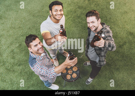 Draufsicht der glückliche junge Freunde, trinken Bier und Grill zu machen Stockfoto