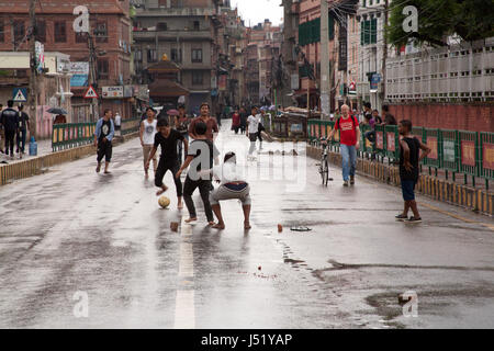 Jugend-Fußball spielen in der Regel viel befahrenen Pulchowk Gabahal Straße auf den Tag der ersten Kommunalwahlen in 20 Jahren, Patan / Nepal Lalitpur Stockfoto