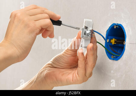 Händen der Elektriker Installation Steckdose mit Schraubendreher Stockfoto