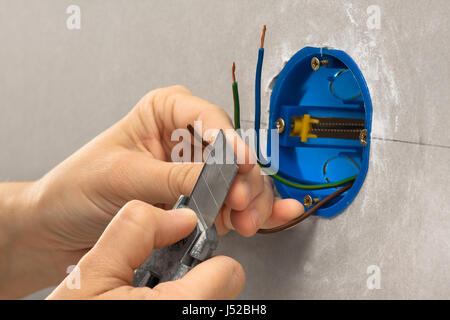 Hand des Elektrikers striping die Isolierung von Drähten mit Briefpapier Messer Stockfoto