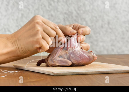 Hände von Frau Wachtel vorbereiten, Kochen auf Holzbrett Stockfoto