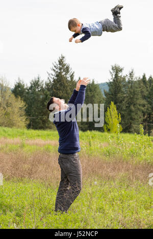 Vater warf Sohn in Luft Stockfoto