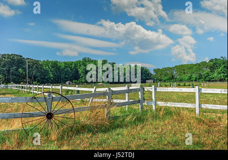 Pferdestall in Maryland an einem Sommertag mit rustikale Wagenrad und Zaun Stockfoto