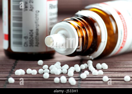 homöopathische Tabletten herausfallen verärgert Fläschchen verstreut Stockfoto