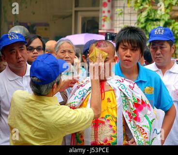 KAOHSIUNG, TAIWAN--16. März 2014: bei einer religiösen Zeremonie ein nicht identifizierter Mann Geist Geld verwendet, um das Blut aus einer selbst zugefügte Wunde wischen auf die Stockfoto