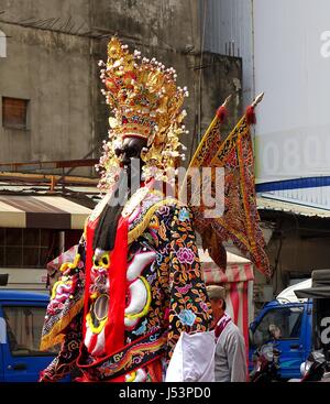 KAOHSIUNG, TAIWAN--16. März 2014: eine große Statue auf Stelzen, die eine populäre Gottheit ist durch die Straßen als Teil einer religiösen Cerem vorgeführt Stockfoto