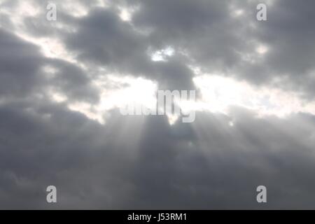 Sonnenstrahlen durchscheinen bedecktem Himmel Stockfoto