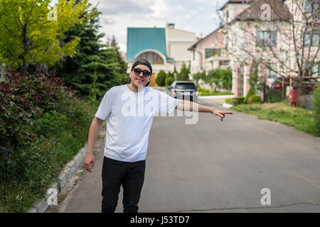 Junge Hipster Mann mit Sonnenbrille per Anhalter unterwegs Stockfoto