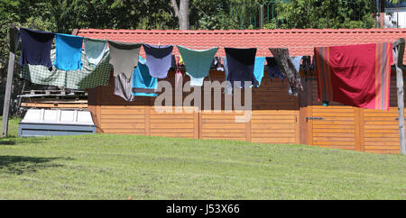 Viele Kleider, die an einem sonnigen Sommertag im Garten liegen Stockfoto