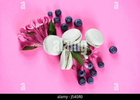 Heidelbeeren mit Makronen unter Blumen Stockfoto