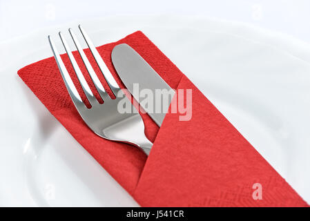 Besteck in einer roten gefaltete Serviette auf Tellern im restaurant Stockfoto