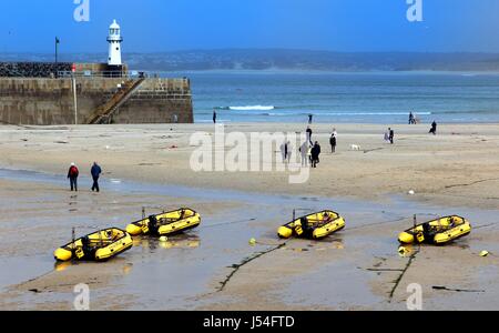 St. Ives, Cornwall, UK 3. April 2017: Passanten vorbei Schlauchboote Zugehörigkeit zu St Ives Self Drive Boat Verleih im Hafen bei Ebbe Stockfoto