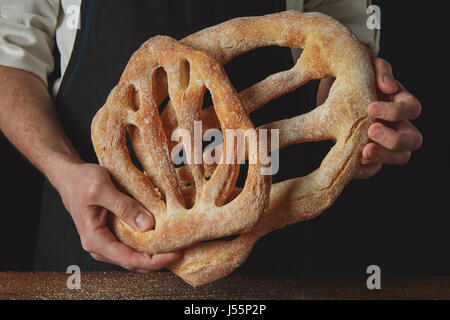 Baker hält Fougas Brot Stockfoto