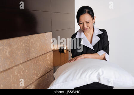 Schöne Brünette Frau hält eine Kissen Stockfoto