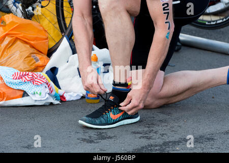 Männlichen Konkurrenten setzen auf Nike Laufschuhe, Übergang Bereich, Stratford Triathlon, UK Stockfoto