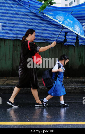 Bangkok. 16. Mai 2017. Eine Frau hält einen Regenschirm für die Tochter auf dem Weg zur Schule in Bangkok, Thailand, 16. Mai 2017. Die meisten Schulen in Thailand begann ein neues Semester am Dienstag, nach einer zweimonatigen Sommerferien von März bis Mai. Bildnachweis: Li Mangmang/Xinhua/Alamy Live-Nachrichten Stockfoto