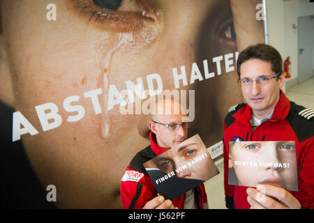 München, Deutschland. 16. Mai 2017. Notfallhelfer Andreas Bayer (L) und Dietmar Gehr halten Postkarten mit Sprüchen zur Sensibilisierung für die Gefahren von zu beschleunigen sowie die Benutzung eines Mobiltelefons in München, Deutschland, 16. Mai 2017. Foto: Peter Kneffel/Dpa/Alamy Live News Stockfoto