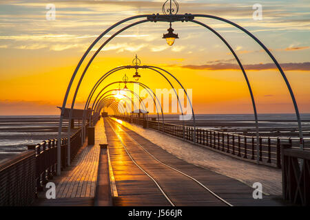 Southport, Merseyside, England. 16. Mai 2017. Großbritannien Wetter. Farbenfrohen Sonnenuntergang über Southport den viktorianischen Pier als Wanderer und Radfahrer nehmen Übung auf 2. längste Pier in England.  Clearing-Himmel am Abend nach ein Tag voller Sonnenschein und Duschen, aber die Prognose für den Regen zurück ist.  Bildnachweis: MediaWorldImages/AlamyLiveNews Stockfoto