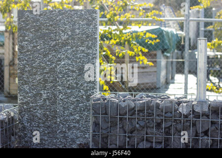 Natur Stein Granit Stelen mit Granit Kies Zaun. Gabione Gartenmauer Stockfoto