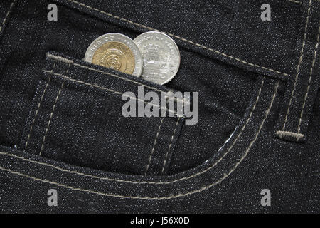 Thai bath Münzen ragte aus der schwarzen Jeans-Tasche. Hautnah. Stockfoto