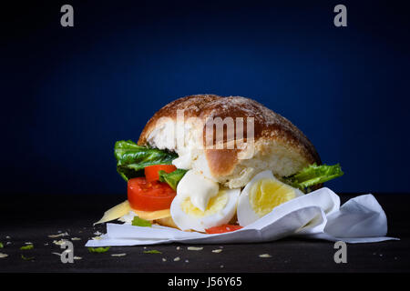 Leckere Burger mit Ei, Tomaten, Käse, Salat und Mayonnaise auf hölzernen Theke. Kopieren Sie Raum. Stockfoto