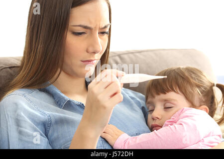 Nahaufnahme einer Mutter, überprüfen die Temperatur ihres kranken Kindes mit einem Thermometer auf einer Couch im Wohnzimmer zu Hause Stockfoto