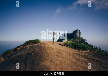 junge freigeistigen Frau genießt den Wind am Pedra Bonita Berg in Rio De Janeiro, Brasilien Stockfoto