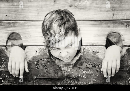 Kaukasische junge im mittelalterlichen Pranger. Negative Emotionen. Schwarz / weiß Foto. Strafe-Gerät. Stockfoto