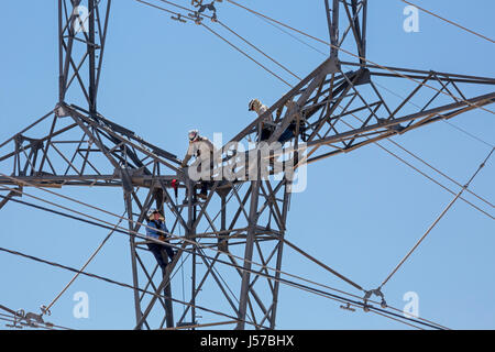 Tucson, Arizona - Arbeiter auf eine hohe Spannung der elektrischen Übertragung Turm in Tucson Electric Power H. Wilson Sundt Generating Station. Stockfoto