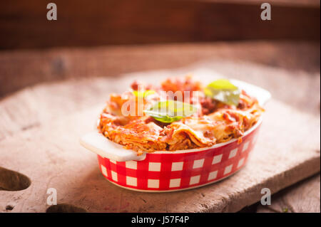 Lasagne Bolognese in einer Auflaufform auf einem rustikalen Tisch Stockfoto