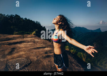 junge freigeistigen Frau genießt den Wind am Pedra Bonita Berg in Rio De Janeiro, Brasilien Stockfoto