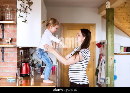 Schöne junge Mutter und Tochter in der Küche. Stockfoto