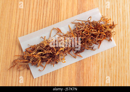 Zigarette-Tissue-Papier und Tabak auf Holzbrett von oben Stockfoto