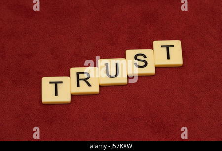 Vertrauen Sie Zeichen. Loyalität-Konzept. Elfenbein Fliesen mit großen Buchstaben auf rotem Velours. Stockfoto