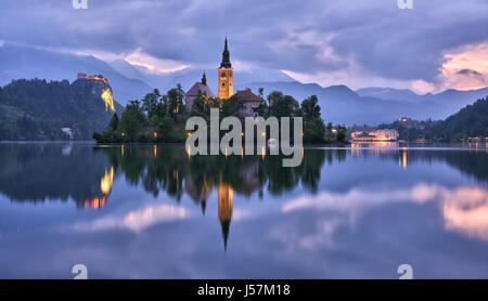 Kirche Mariä Himmelfahrt im See von Bled mit der Burg im Hintergrund, Slowenien Stockfoto