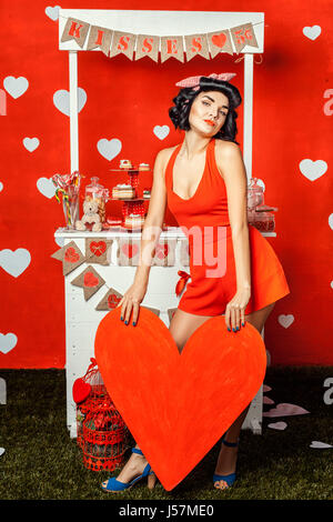 Mädchen mit großen roten Papierherz in Händen. Stockfoto