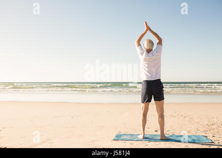 Ansicht der Rückseite des älteren Mannes stretching am Strand Stockfoto