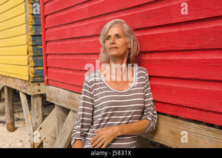 Nahaufnahme von senior Frau wegsehen stehend von Hütte am Strand Stockfoto