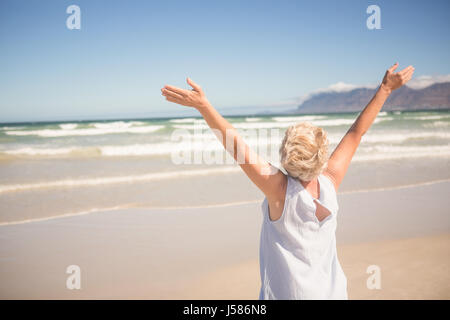 Rückansicht des Frau mit Armen erhöht stehen am Ufer am Strand Stockfoto