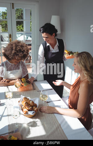 Kellnerin Speisen an Kunden im restaurant Stockfoto