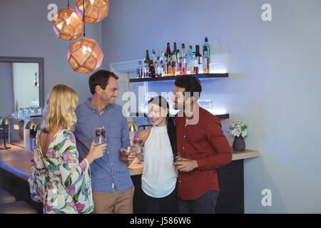 Zwei Paare, die zusammen mit Cocktails in bar restaurant Stockfoto