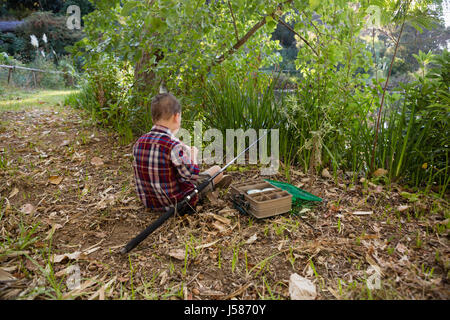 Rückansicht des jungen Vorbereitung einen Köder im Wald Stockfoto